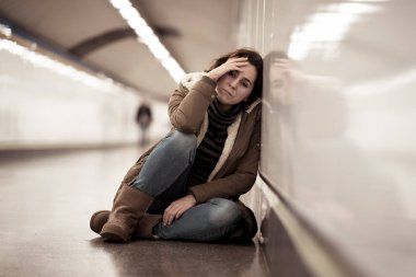 Young adult felling shame depressed and hopeless sitting alone on subway city ground in Depression Loneliness Mental health Emotional pain Social violence Abusive relationship and Harassment concept. clipart