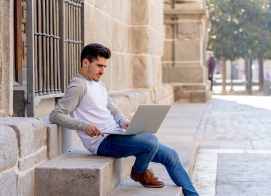 Dizüstü bilgisayar bloglama üzerinde çalışma, online sohbet ve e-posta bir Avrupa şehri açık havada kontrol trendy delikanlı. Öğrenci yaşam tarzı, teknoloji, eğitim ve uzak çalışma kavramı.