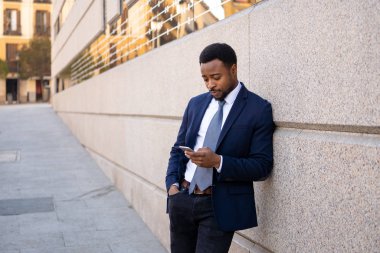 Genç adam akıllı aşınmaya üstünde hareket eden telefon açık havada city adlı metin e-posta ya da sosyal medya app sokak gönderme. Mutlu iş adamları, girişimci ve iş özgürlük iletişim teknoloji dışında çalışma.