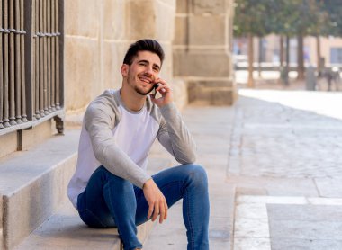 Söz ve akıllı telefon üzerinde sosyal medya arkadaşıyla tatil günlerinde Avrupa'da sohbet mutlu onun yirmili genç çekici adam. İletişim, teknoloji internet ve yaşam tarzı konsepti.