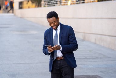 Genç adam akıllı aşınmaya üstünde hareket eden telefon açık havada city adlı metin e-posta ya da sosyal medya app sokak gönderme. Mutlu iş adamları, girişimci ve iş özgürlük iletişim teknoloji dışında çalışma.