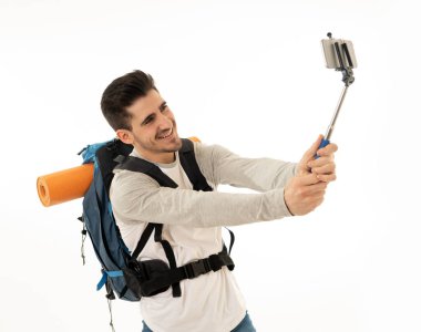 Beyaz arka plan üzerinde izole onun cep telefonu ile bir selfie alarak genç backpacker portresi. Turizm ve sosyal ağ, bağlı, kalmak dünya çapında seyahat rüya kavramı yaşayan.