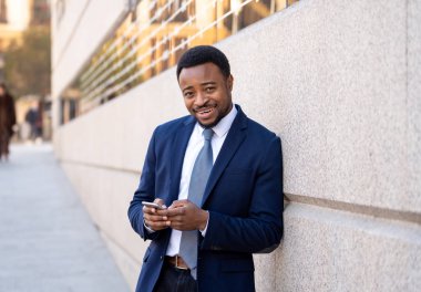 Genç adam akıllı aşınmaya üstünde hareket eden telefon açık havada city adlı metin e-posta ya da sosyal medya app sokak gönderme. Mutlu iş adamları, girişimci ve iş özgürlük iletişim teknoloji dışında çalışma.