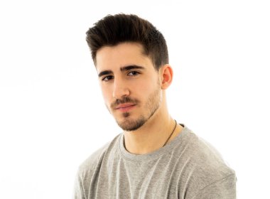 Çekici, portresi bakarak tarafsız, rahat ve ciddi insanlar yüz ifadeleri, insan duyguları, başarı ve eğitim kavramı kendine güvenen genç adam kapatın. Gri arka plan üzerinde izole.