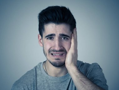 Sefil, melankoli ve üzgün seyir depresyon acı üzerinde nötr arka plan izole ağlıyor yakışıklı genç adam portresi kapatın. İnsanlar insan yüz ifadeleri ve duygu kavramı.