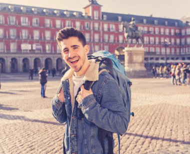 Genç turizm öğrenci adam onun yirmili mutlu ve heyecanlı hareket yukarı Plaza Mayor, Madrid, İspanya, gösterilen eğleniyor. Tatil, seyahat ve Avrupa ve özgürlük kavramı etrafında backpacking.