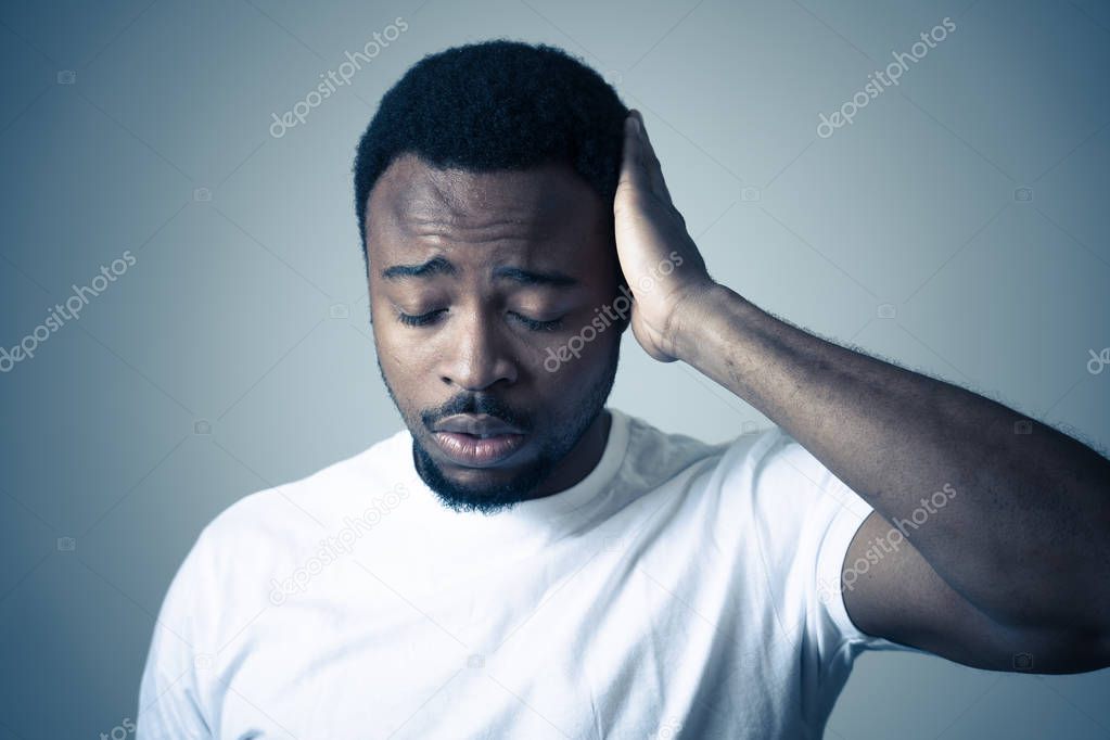Portrait of african american adult in pain with sad and exhausted face looking concerned, worried and thoughtful in human emotions, facial expression and Depression. Isolated on neutral background.