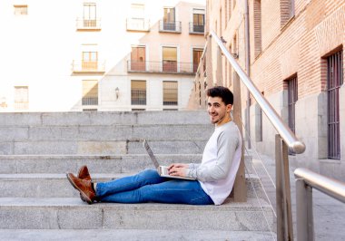 Dizüstü bilgisayar bloglama üzerinde çalışma, online sohbet ve e-posta bir Avrupa şehri açık havada kontrol trendy delikanlı. Öğrenci yaşam tarzı, teknoloji, eğitim ve uzak çalışma kavramı.