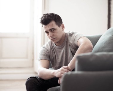Mutsuz depresif beyaz erkek ağlama ve umutsuz hissediyorum oturma odası koltukta yalan oturan vurguladı yalnız bir iş, işsizlik, anksiyete kalbi kırık ve depresyon üzüntü kavramı.