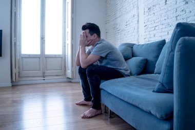 Mutsuz depresif beyaz erkek ağlama ve umutsuz hissediyorum oturma odası koltukta yalan oturan vurguladı yalnız bir iş, işsizlik, anksiyete kalbi kırık ve depresyon üzüntü kavramı.