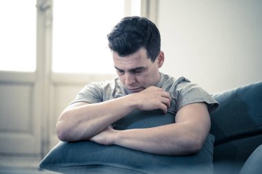 Depresyonda ve umutsuz tek başına eve acı duygusal acı ve mutsuzluk kanepe ağlıyor felling genç adam portresi. İnsanlar kırık kalp içinde kavramı depresyon zorbalık ve akıl sağlığı sorunları.