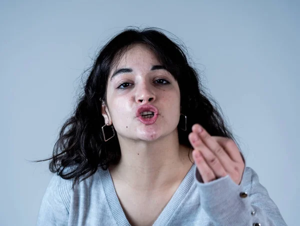 Facial expressions and emotions. Close up portrait of Young attractive hispanic woman with an angry face. Looking mad and crazy shouting and making furious gestures. Isolated on moody background.