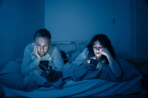 Retrato Estilo Vida Jovem Casal Entediado Cama Noite Telefones Inteligentes — Fotografia de Stock