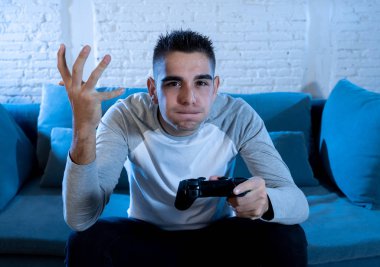 Genç adam eğleniyor portresi kazanan kutluyor ucube yoğun mutlu yüz ile kablosuz uzaktan joystick kullanarak video oyunları oynamak. Konsol erkek oyun bağımlılığı istasyonu ve video oynamak.