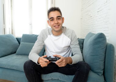 Video having oyunculuk ile konsol oyun İstasyonu ve video erkek oyun bağımlılığı ucube yoğun mutlu yüzüne kablosuz uzaktan joystick kullanarak oyunu kazanma oyunları oynamak genç öğrenci adam portresi.