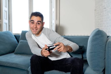 Video having oyunculuk ile konsol oyun İstasyonu ve video erkek oyun bağımlılığı ucube yoğun mutlu yüzüne kablosuz uzaktan joystick kullanarak oyunu kazanma oyunları oynamak genç öğrenci adam portresi.