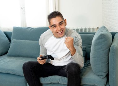 Video having oyunculuk ile konsol oyun İstasyonu ve video erkek oyun bağımlılığı ucube yoğun mutlu yüzüne kablosuz uzaktan joystick kullanarak oyunu kazanma oyunları oynamak genç öğrenci adam portresi.