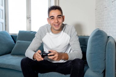 Video having oyunculuk ile konsol oyun İstasyonu ve video erkek oyun bağımlılığı ucube yoğun mutlu yüzüne kablosuz uzaktan joystick kullanarak oyunu kazanma oyunları oynamak genç öğrenci adam portresi.