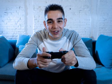 İskambil video spor freak yoğun mutlu yüz ile kablosuz uzaktan joystick kullanarak oyunu kazanma eğleniyor genç öğrenci adam portresi. Konsol erkek oyun bağımlılığı istasyonu ve video oynamak.