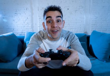İskambil video spor freak yoğun mutlu yüz ile kablosuz uzaktan joystick kullanarak oyunu kazanma eğleniyor genç öğrenci adam portresi. Konsol erkek oyun bağımlılığı istasyonu ve video oynamak.