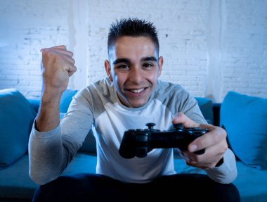 Genç adam eğleniyor portresi kazanan kutluyor ucube yoğun mutlu yüz ile kablosuz uzaktan joystick kullanarak video oyunları oynamak. Konsol erkek oyun bağımlılığı istasyonu ve video oynamak.