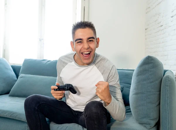 ビデオゲーム コンソール プレイ ステーションやビデオの男性のゲーム中毒でフリーク強烈な幸せそうな顔で無線リモート ジョイスティックを使用してゲームに勝つ楽しんで若い学生の男のポートレート — ストック写真