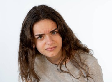 Kızgın bir yüz genç ve güzel bir beyaz kız portresi kapatın. Çileden ve kızgın kameraya arıyorum arıyorum. İnsan yüz ifadeleri ve duygular. Beyaz arka plan üzerinde izole.