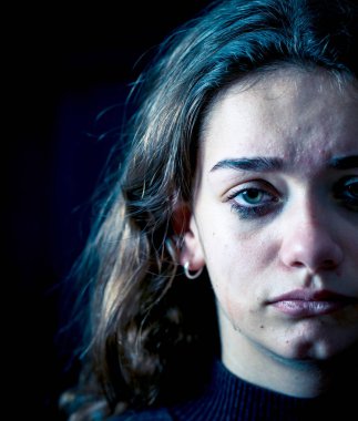 Ağlayan bir okulda, depresif, yalnız, yorgun, stresli genç çocuk kız closeup. Siyah arka plan üzerine izole. İnsan duyguları, çocukluk depresyon, duygusal acı. Zorbalık ve çocuk istismarı kavramı.