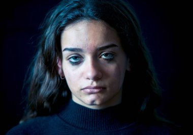 Ağlayan bir okulda, depresif, yalnız, yorgun, stresli genç çocuk kız closeup. Siyah arka plan üzerine izole. İnsan duyguları, çocukluk depresyon, duygusal acı. Zorbalık ve çocuk istismarı kavramı.