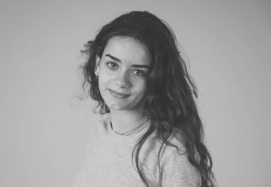 Siyah beyaz portre sevimli gülümseme ve şık bir görünüm ve pozlar güzel genç genç kadının kapatın. Mutluluk, güzellik ve moda ve insanlar kadın kavramı. Gri arka plan üzerinde izole.