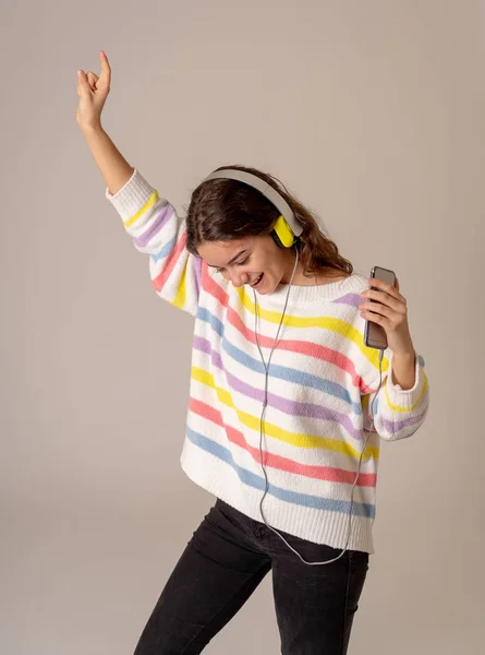 快乐的肖像华丽和欢快的少女听音乐在耳机唱歌和跳舞在中性的背景 在积极的情感 休闲和技术的概念 — 图库照片