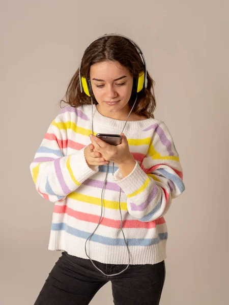 华丽和快乐的少女的肖像听音乐在耳机寻找最喜欢的歌曲在手机上孤立的中性 在积极的情感 休闲和技术的概念 — 图库照片