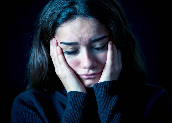 Драматический крупный план портрета молодой напуганной, подавленной девушки, плачущей в одиночестве, чувствующей себя безнадежной, страдающей от домогательств или домашнего насилия. Прекратить жестокое обращение с детьми и пренебрежение. Концепция социальной кампании
.