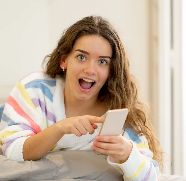 スマート フォンの信者をチェックし インターネット ソーシャル メディア 新しい技術コンセプトの家でモバイル アプリケーションを使用してオンライン チャットで幸せな魅力的な若い 代女性 — ストック写真