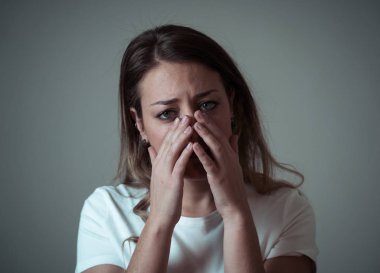 Güzel genç kadın portresi kadar sefil ve melankoli bakarak üzgün ruh hali ile kapatın. İnsan yüz ifadeleri ve duygular, depresyon ve ruh sağlığı kavramı. Nötr arka plan üzerinde izole.