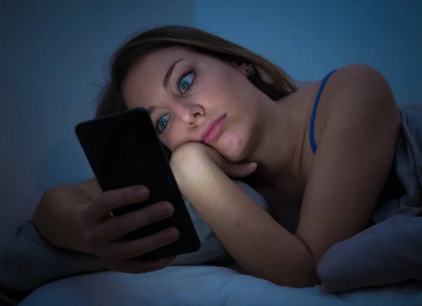 중독된 침대에서 모바일 중독과 개념에 그녀의 스마트 전화를 인터넷 — 스톡 사진