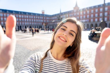 Güzel genç turist öğrenci mutlu ve heyecanlı Plaza Mayor kamerayı ve plaza Mayor Madrid İspanya bir selfie alarak Madrid. Seyahat etmek turizm, Avrupa şehri, Avrupa ve bağlantıları.