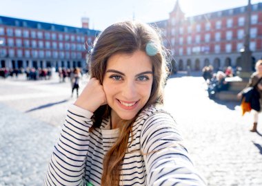 Güzel öğrenci turist kadın mutlu ve heyecanlı selfie kadar yakın Plaza Mayor Madrid seyir içinde neşeli ve sevinçli eğleniyor alarak. Avrupa ve online macera deftere nakil çevresinde turizm, seyahat.