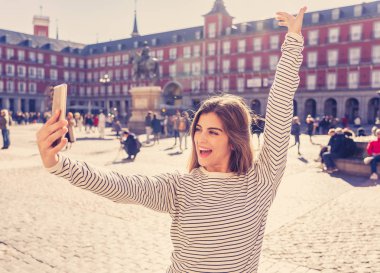 Güzel genç beyaz öğrenci turist kadın bir selfie veya onu turizm ve seyahat etmek çevrede Dünya blog web Plaza Mayor Madrid İspanya için video alma. Sosyal medya ve Avrupa'da tatil.