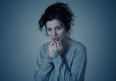 Genç, korkmuş ve korkmuş bir kadının yakın, kendini korkutucu ya da korkutucu bir şey kapsayan. Korku ve anksiyete hissi. Yüz ifadeleri ve duygular kavramı.