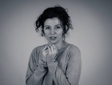 Genç korkmuş ve korkmuş bir kadının siyah beyaz portresini kapatın, korkutucu ya da korkutucu bir şeyden kendini örtün. Korku ve endişe hissediyorum. Yüz ifadeleri ve duygu kavramı.