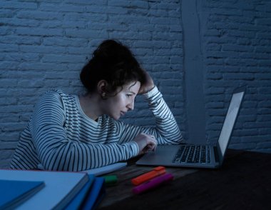 Aşırı çalışmış ve yorgun kadın öğrenci gece geç saatlere kadar çalışan onu laptop uykuya uyumak için değil çalışıyor, endişeli ve üzgün yorgun hissediyorum. Moody koyu ışık. Online öğrenme ve stres iş kavramı.