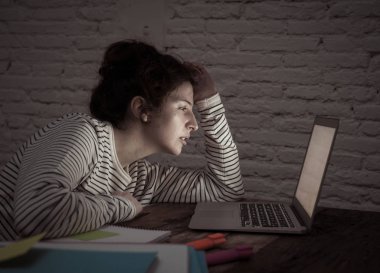 Aşırı çalışmış ve yorgun kadın öğrenci gece geç saatlere kadar çalışan onu laptop uykuya uyumak için değil çalışıyor, endişeli ve üzgün yorgun hissediyorum. Moody koyu ışık. Online öğrenme ve stres iş kavramı.