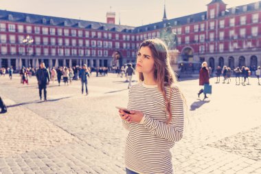 Akıllı cep telefonu yön bulmaya çalışırken kontrol genç turist kadını kaybettim. Endişeli ve düşünceli cep telefonu app danışmanlık arıyorum. Avrupa, İspanya, Madrid ve teknoloji kavram turizm.