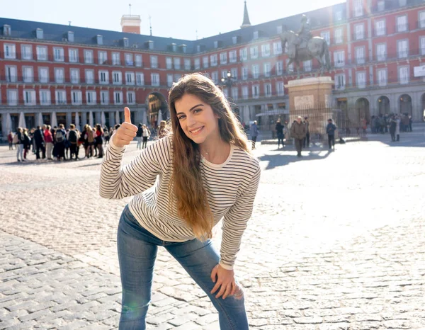 美しい若い観光客女性幸せとプラザ市長マドリード スペイン見て楽しんで 晴れた日で登録して親指をやっている陽気な興奮 ヨーロッパ および学生ギャップ イヤー周辺旅行します — ストック写真