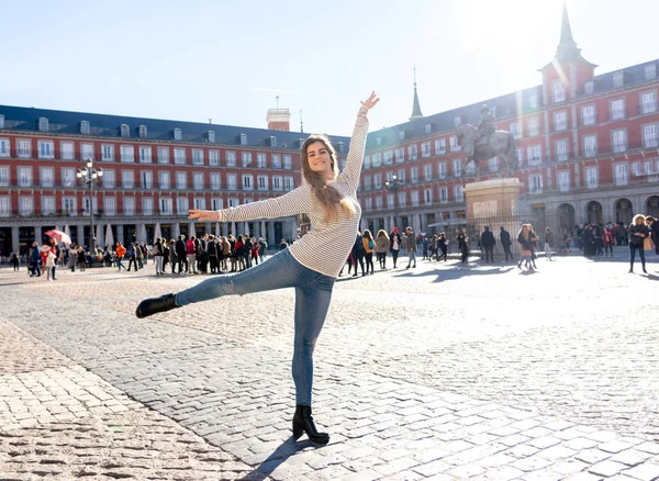 興奮して陽気なポーズとマヨール広場 マドリッド スペインのダンスを見て若い魅力的な女性 ヨーロッパの都市の背景 ヨーロッパのホリデー留学旅行コンセプト — ストック写真