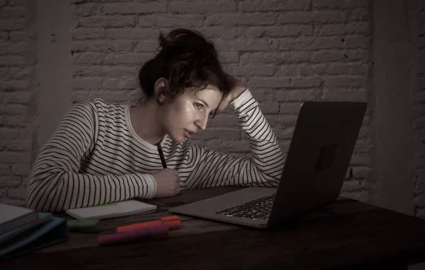 過負荷と疲れた女性の学生は 彼女のラップトップ上で夜遅く働いて 疲れた感じ 心配して悲しくないようにしています ムーディー暗い光 オンライン学習とストレスワークのコンセプト — ストック写真