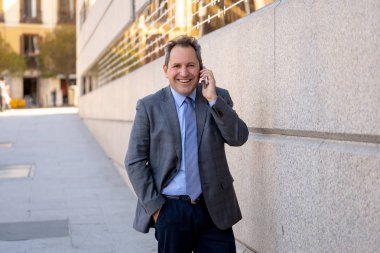 Orta yaşlı işadamı kentsel City akıllı cep telefonunda mutlu insanlar dışında sokak konuşuyor. Sosyal ağ, özgürlük, modern teknoloji ve girişimci yaratıcı iş kavramı.