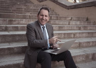 Akıllı telefon e-posta ve sosyal medya şehir merdivenlerde kontrol üzerinde mutlu orta yaşlı işadamı. İnsanlar, yeni teknoloji, online bağlantı ve girişimci yaratıcı iş mobil iletişim kavramı.