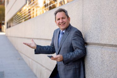 Olgun adam akıllı aşınmaya üstünde hareket eden telefon açık havada city adlı metin e-posta ya da sosyal medya app sokak gönderme. Mutlu iş adamları, girişimci ve iş özgürlük iletişim teknoloji dışında çalışma.